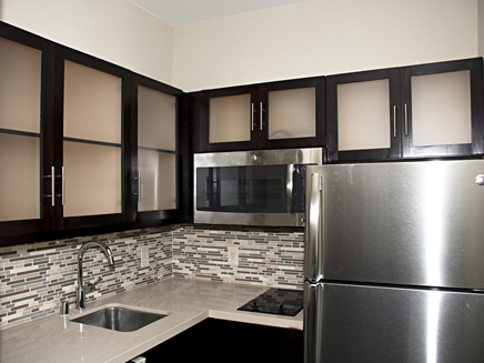 Hotel registration desks feature custom fine-wood construction with inlaid tile accent facing and granite counter and desktops.