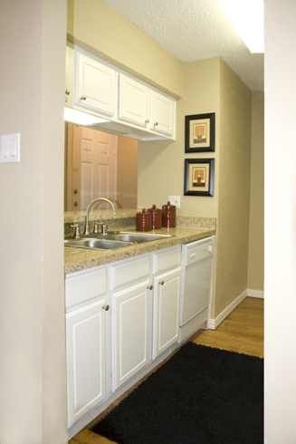 After: Distinctive and inviting renovation sets the tone for galley-style kitchen updating with upscaled granite laminate countertops and repainted and refaced sink and overhead cabinets.