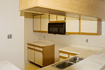Before: Resurfacing and refacing of out-of-date suspended cabinets of yellow oak with white laminate facing